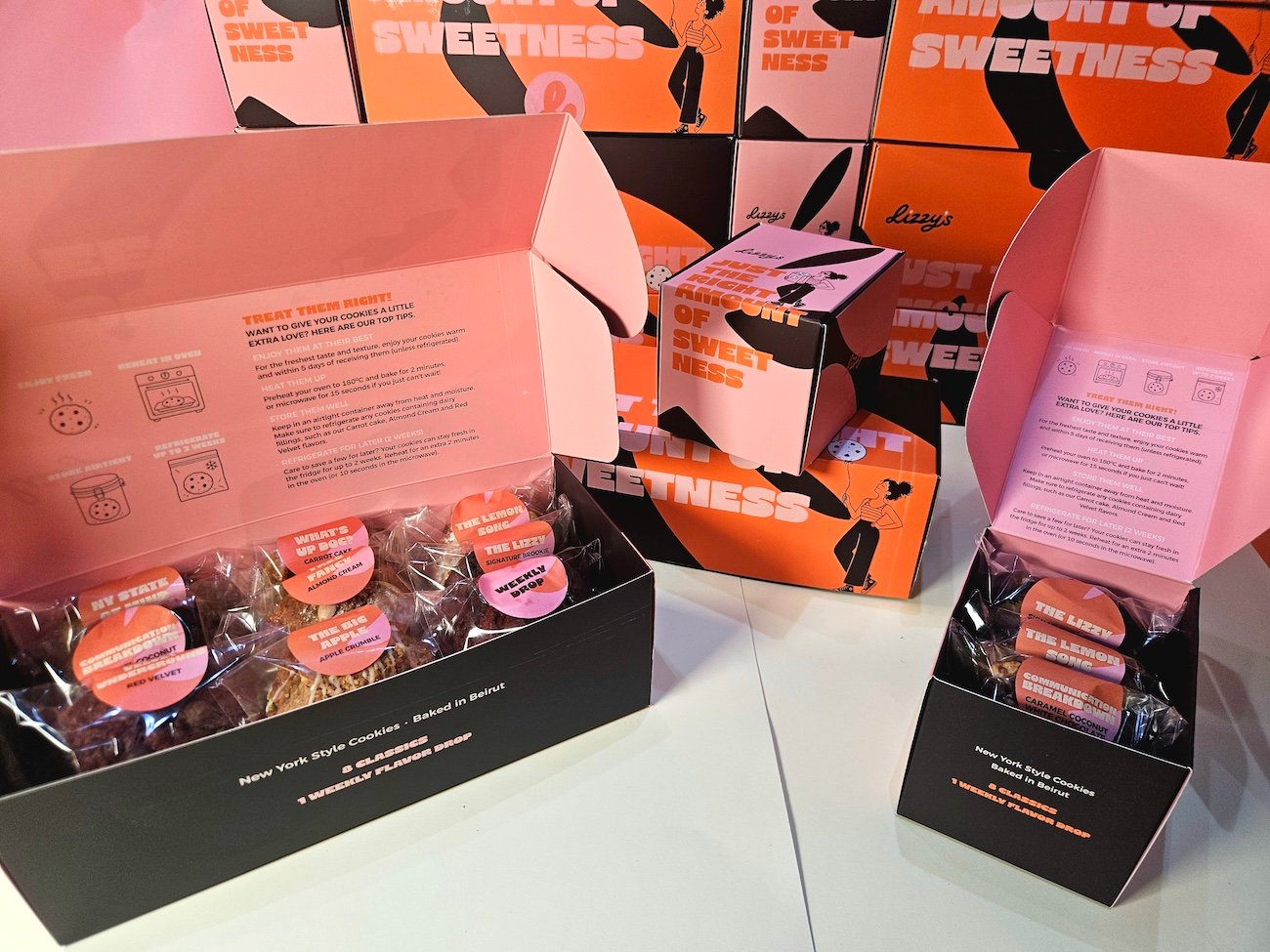 Stack of Lizzy's cookie boxes in orange, pink, cream and brown
